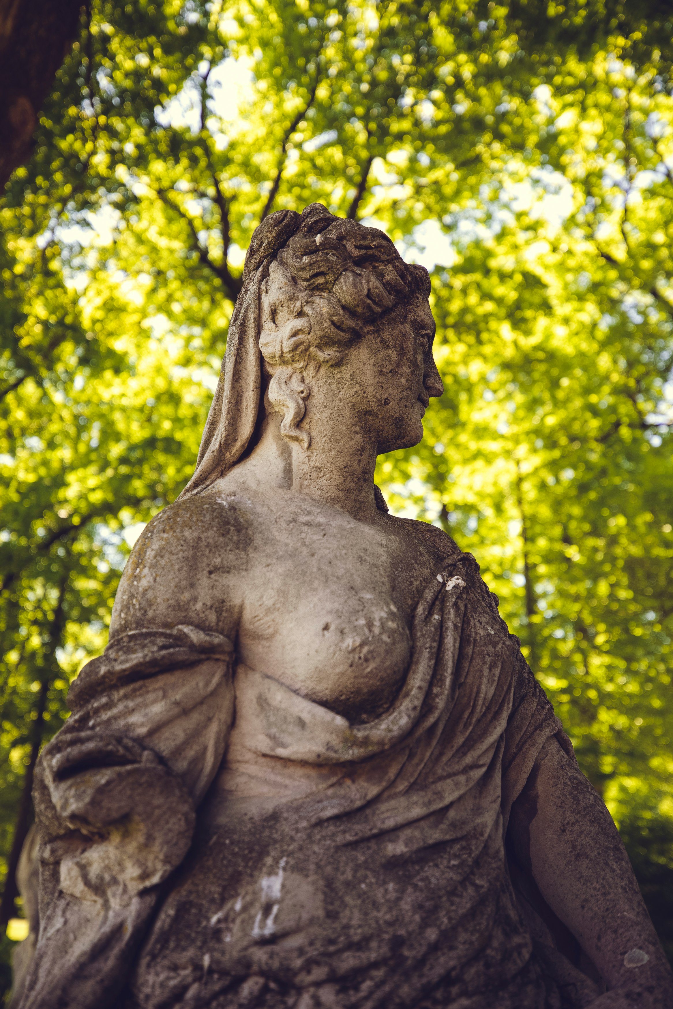 woman statue near green trees during daytime